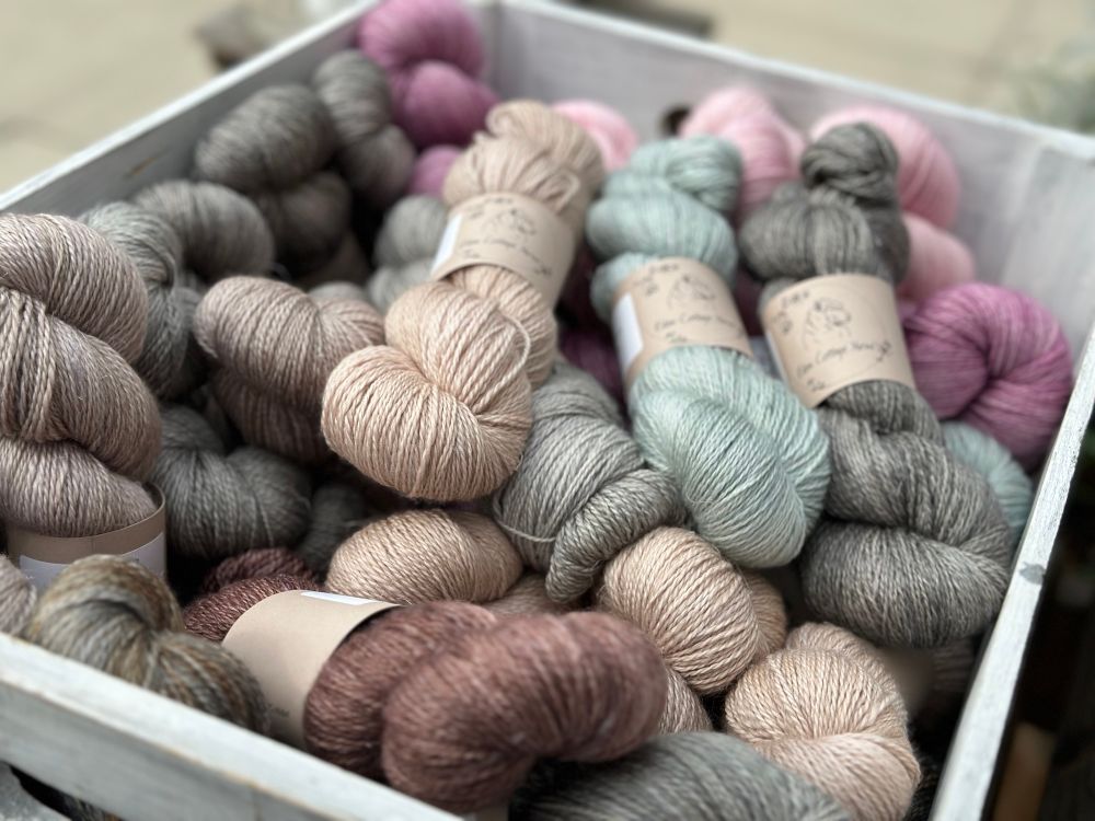 A box full of skeins of hand dyed yarn in soft semi solid colourways 