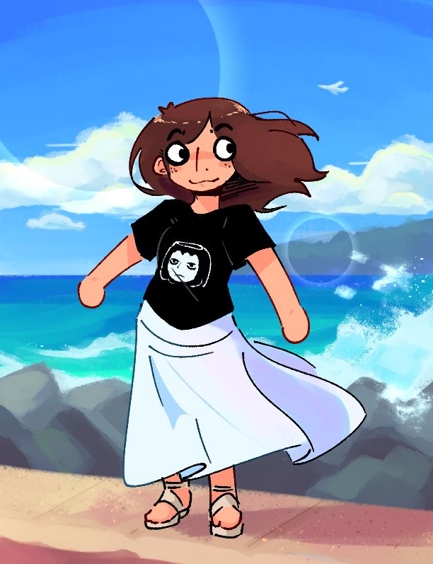me standing on a ledge with some rocks and crashing waves behind me. I'm in a long white skirt and a black mob psycho t-shirt (specifically merch by PaperDawn!)