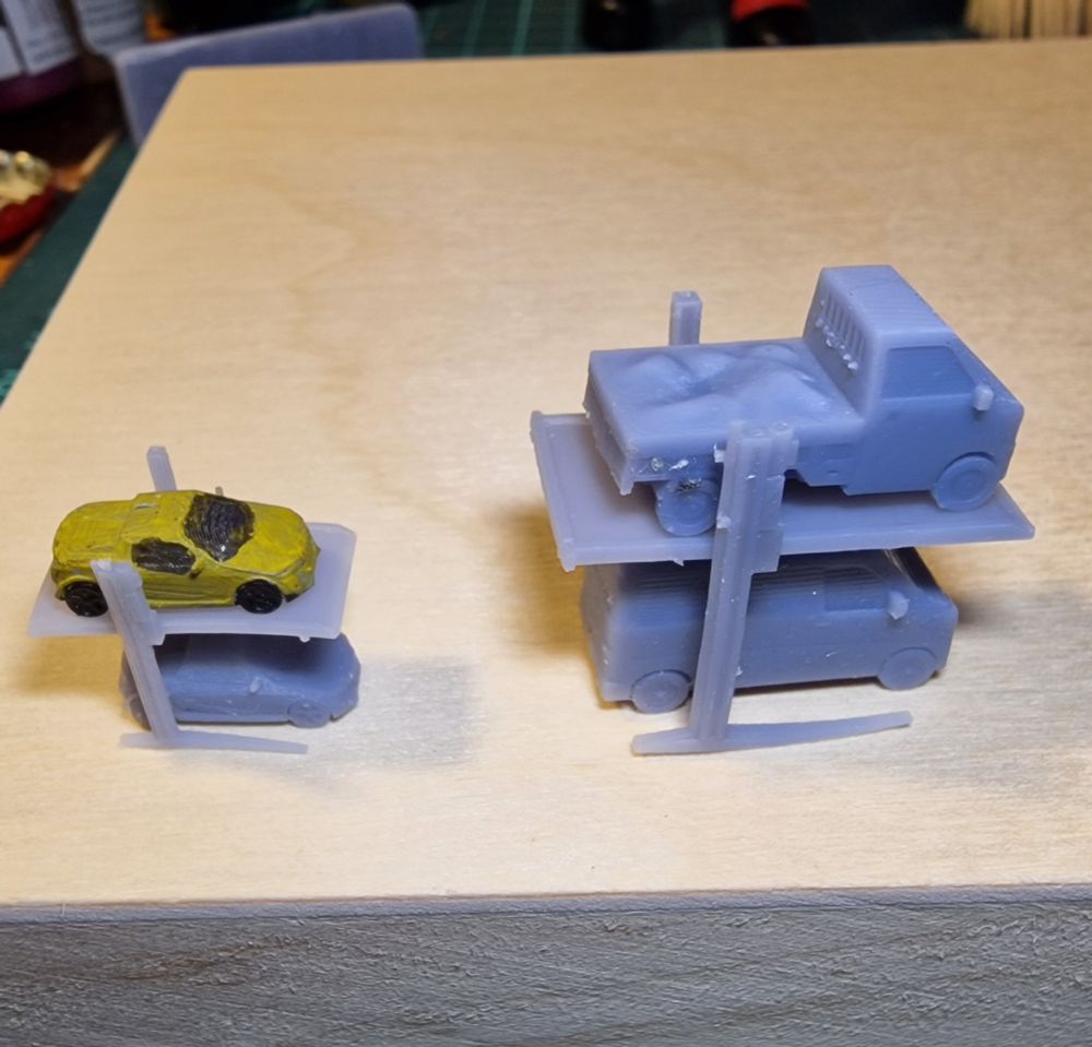 3d printed models of car racks, with cars on them, in two different scales.