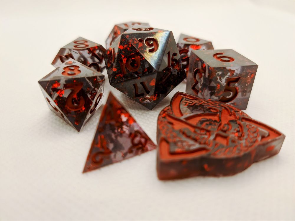 A set of dice that are clear black with red foil on the inside and red inking