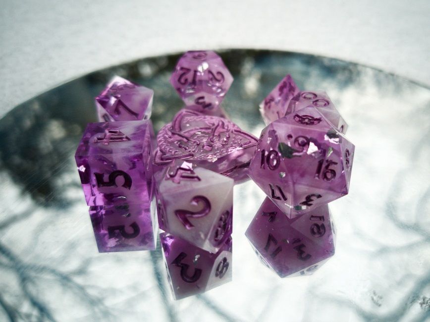 Lavender dice on a mirror reflecting a snowy background