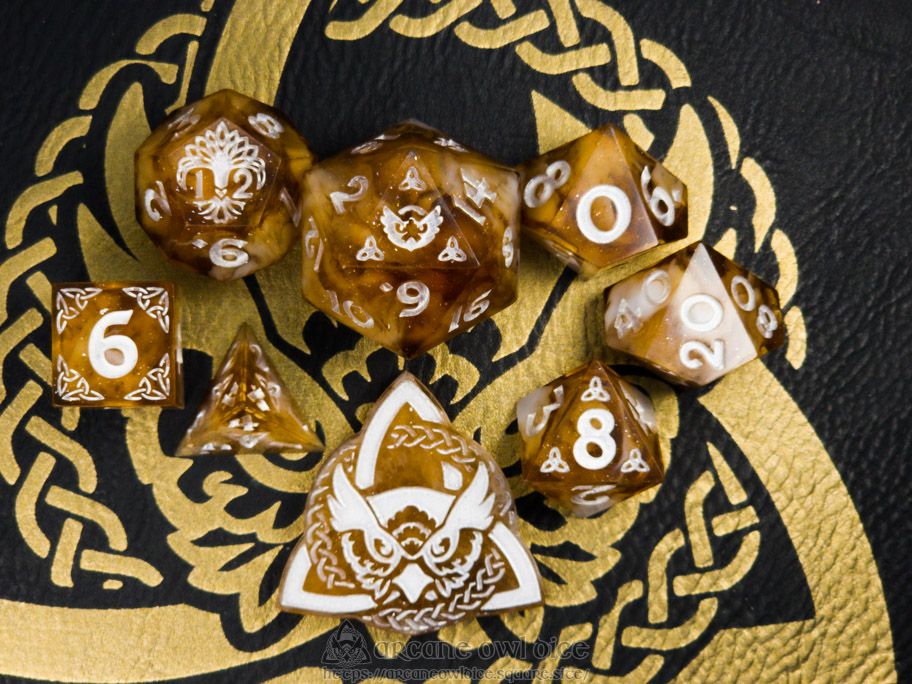 A set of 8 dice that are brown with white swirls and sparkles in them. They are inked in white