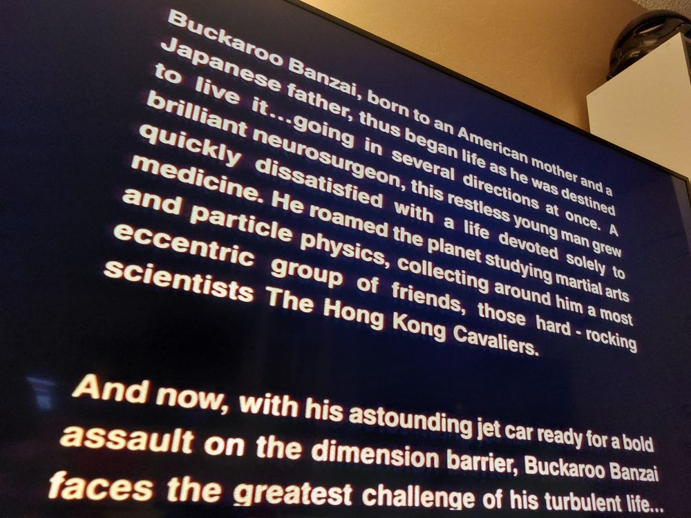 Opening crawl to the movie Buckaroo Banzai. It reads:

Buckaroo Banzai, born to an American mother and a Japanese father, thus began life as he was destined to live it...going in several directions at once. A brilliant neurosurgeon, this restless young man grew quickly dissatisfied with a life devoted soley to medicine. He roamed the planet studying martial arts and particle physics, collecting around him a most eccentric group of friends, those hard - rocking scientists The Hong Kong Cavaliers.

And now, with his astounding jet car ready for a bold assault on the dimension barrier, Buckaroo Banzai faces the greatest challenge of his turbulent life...