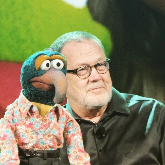 Dave Goelz, wearing a black shirt, holds up Gonzo at the 2015 D23 Expo. (Image courtesy of Muppet Wiki)
