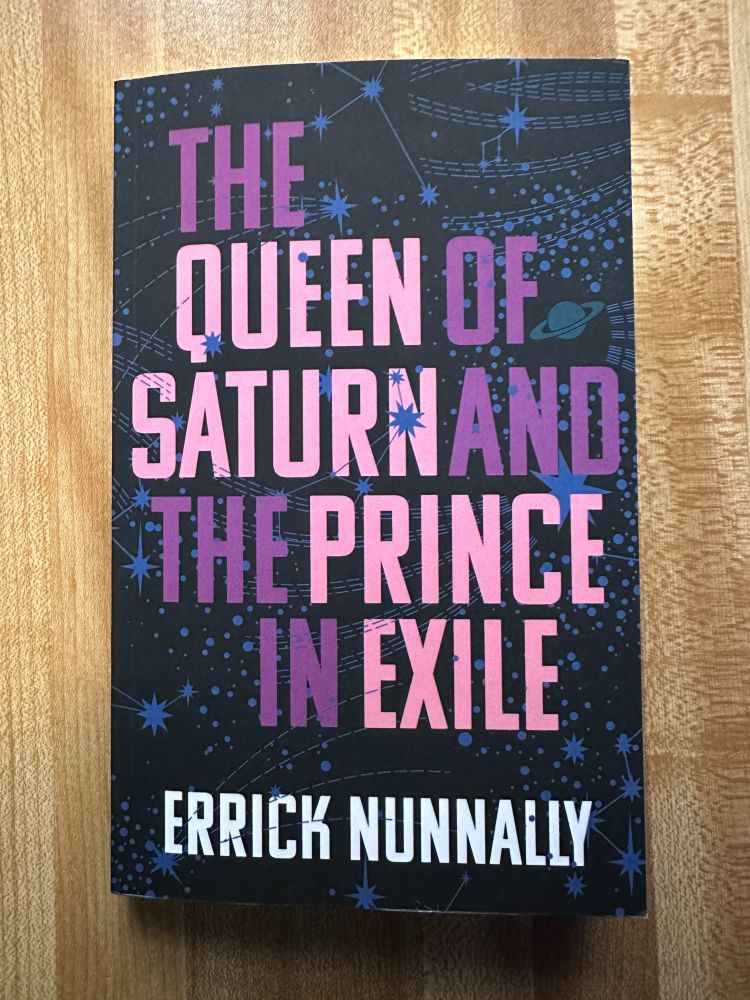 Photo of the book. Title: The Queen of Saturn and the Prince in Exile. Author: Errick Nunnally. Title is rendered in purple and bubblegum pink over a black background with swirling blue stars and the planet Saturn.