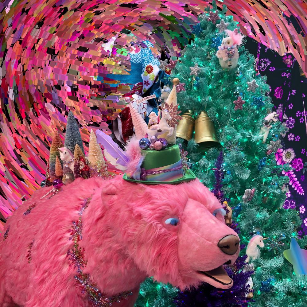 A Tokyo festive display in a shop. There is a large pink polar bear with Christmas trees on its back. It is wearing a green hat with brightly coloured feathers and other Christmas decorations adorning it.