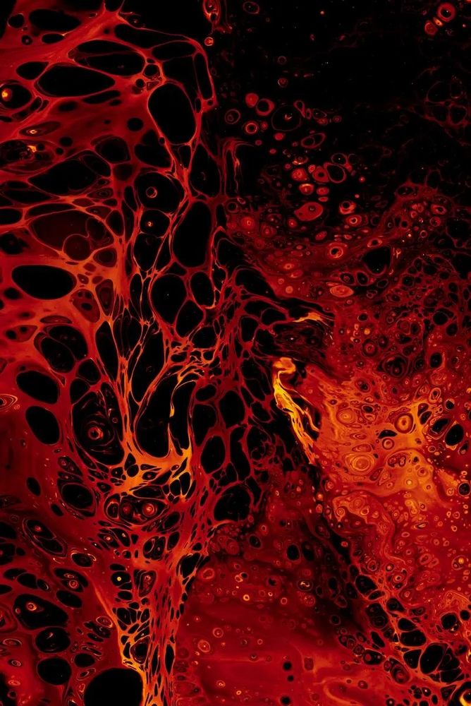 Abstract image of swirling red and orange, looking a little like an explosion of lava thrown up from an eruption: Solen Feyissa on Unsplash.