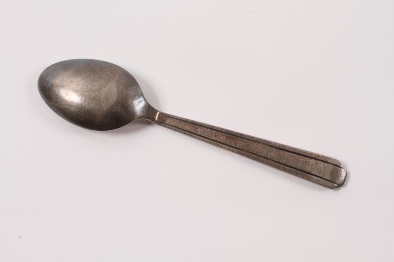 Spoon, silver, taken by Holocaust survivor from the Warsaw Ghetto when she escaped from there (underside view).