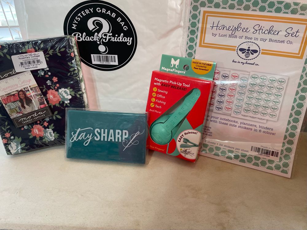 Free Mystery Grab bag with my quilting order from Fat Quarter Shop: 6 fat quarters in navy blue pink & green with patterns flowers, cris cross, small circles by Camille Roskelley; green magnetic pick-up pins tool with easy release; honey sticker set of 6- 24 per sheet by Lori Holt to decorate binders, planner, notebook; navy/green magnetic needle case.
