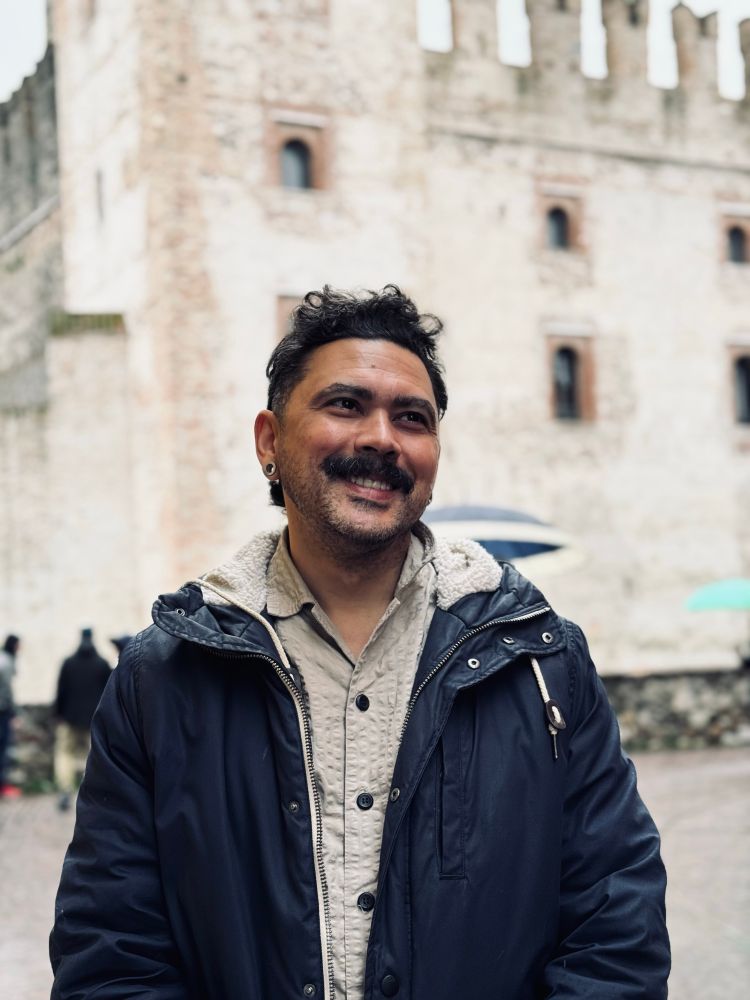 Nivas smiling in front of the castle of Sirmione