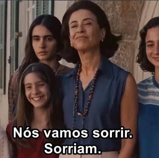 Cena do filme "ainda estou aqui"

Eunice e família posando para uma foto. Na legenda "nós vamos sorrir. Sorriam."