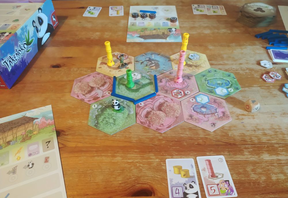 Brauner Küchentisch, darauf aufgebaut das Familienbrettspiel Takenoko.