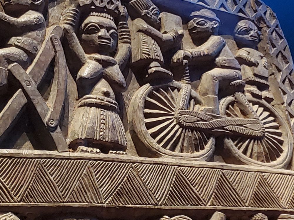 Détail de la porte sculptée: un autre personnage sur un vélo