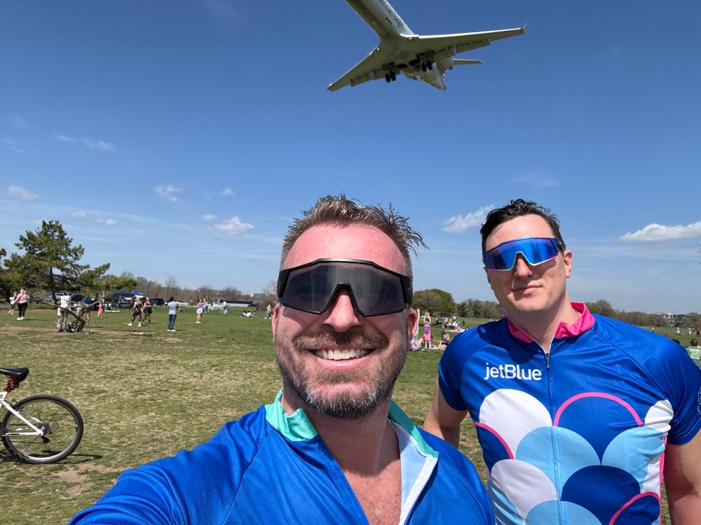 Two cyclists taking a break as a plane lands