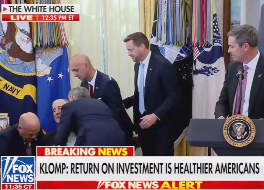 "Klomp: Return on Investment is Healthier Americans" reads the chyron as they attend to a guy who just bottomed out at the White House.
