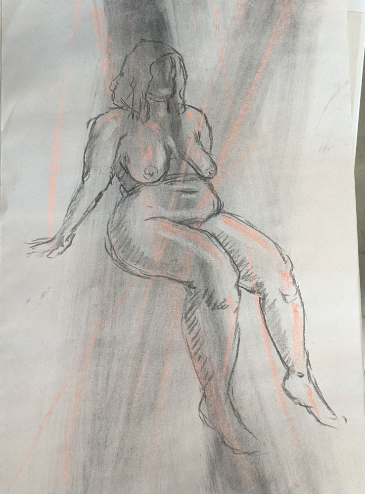 A nude female model sits at the edge of a raised platform and lets her lower legs hang over the edge, and she leans back onto both arms.