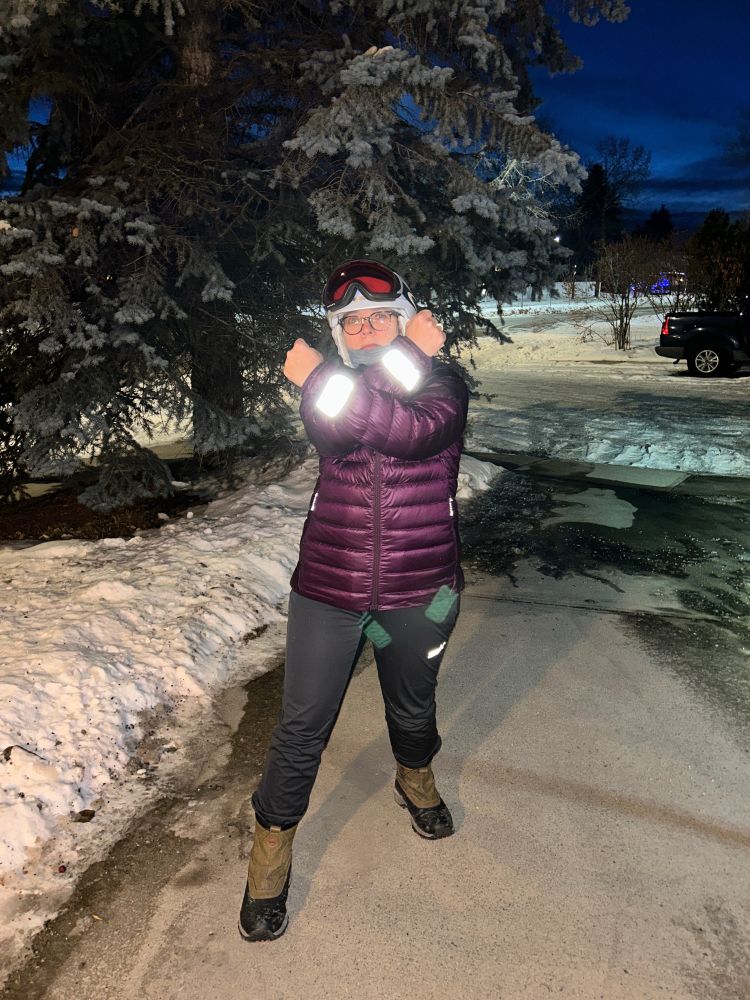 Person wearing reflective armbands to be seen while biking at night.