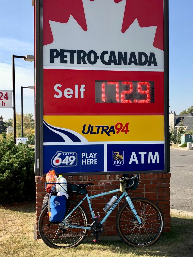 Groceries on a Brodie Elan Vital gravel bike in front of a gas price sign.