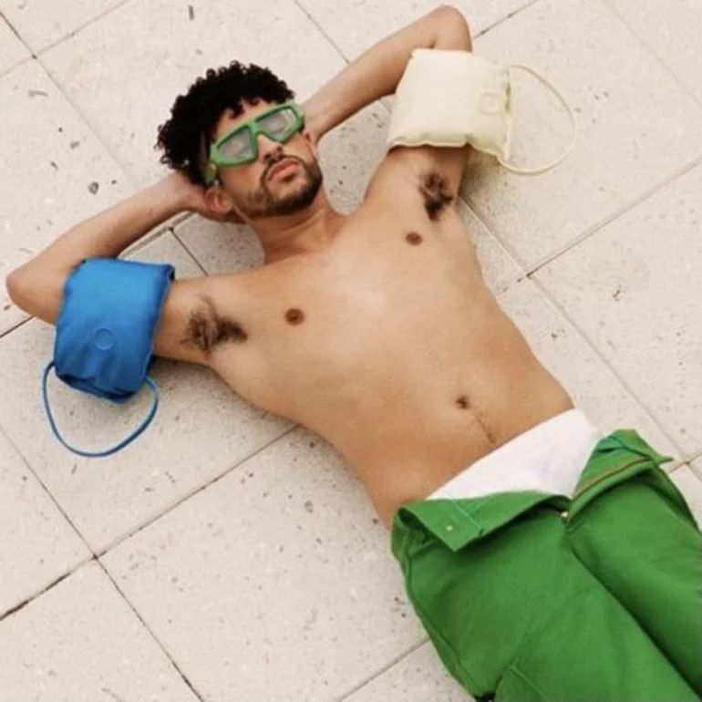 bad bunny laying down with his arms behind his head showing his armpits