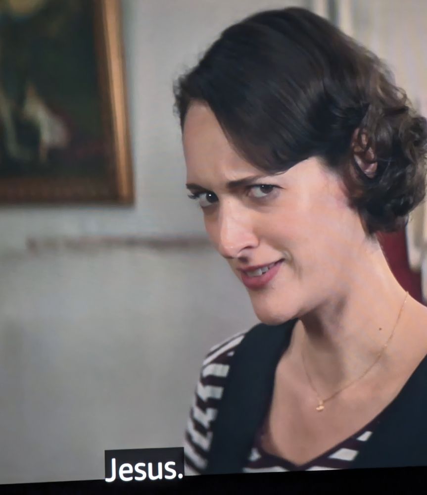 Phoebe Waller-Bridge as Fleabag peering into the camera with a concerned look on her face. A caption is on-screen reading 'Jesus' as in disbelief