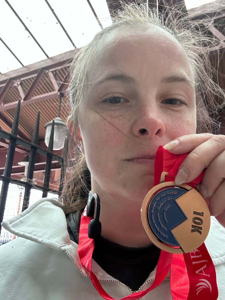 Holding the 10K medal.