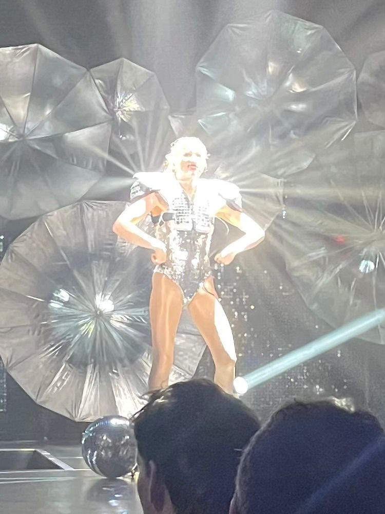 Performer in glitter-ball costume lit up by spotlights