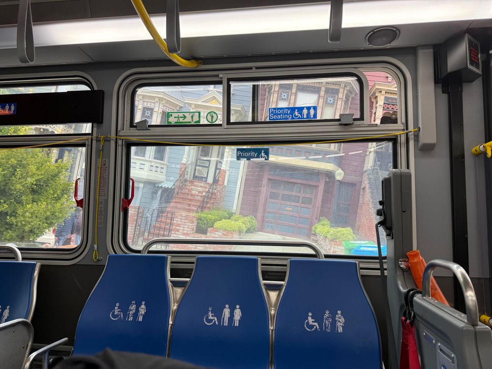 Shot inside the bus aligned with the bus, with the outside of two different houses at a crazy angle going downhill 