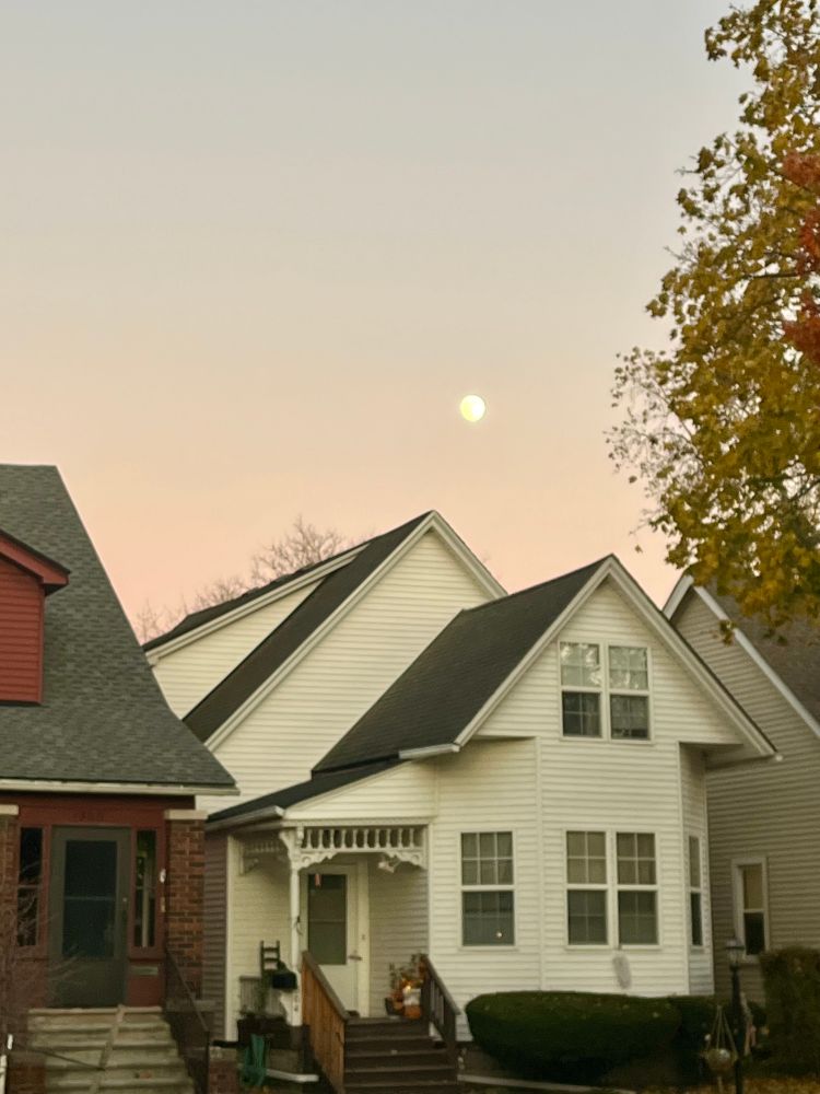 Moon rising over a house