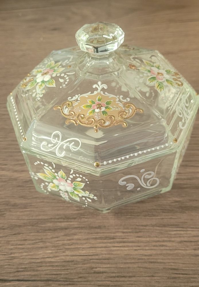 A glass bowl with a glass lid. There’s pretty flowers and patterns painted on it.
