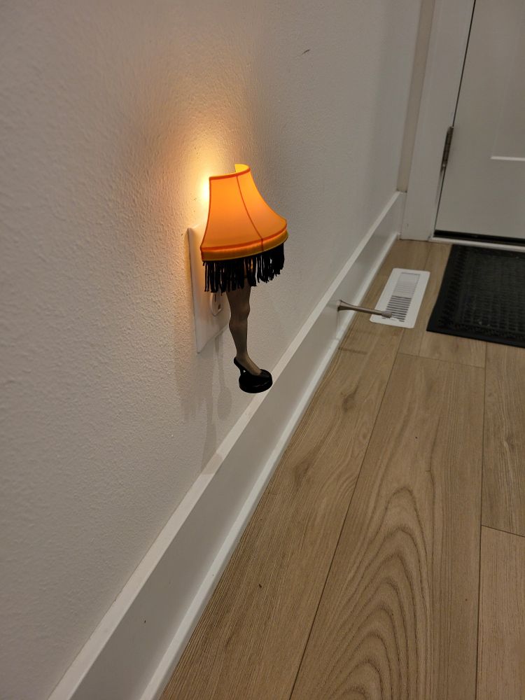Night light version of the leg lamp from "A Christmas Story" plugged into wall outlet. 