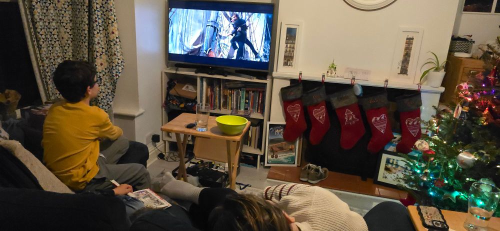 The family of two boys and their mother is watching Goonies on TV