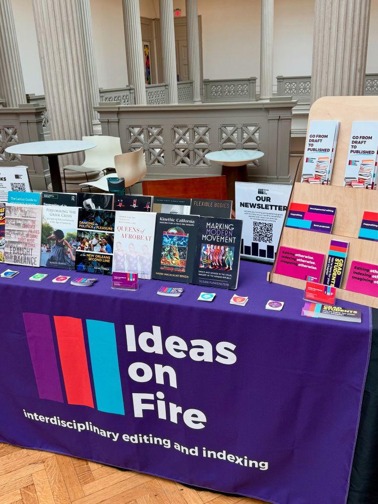 Ideas on Fire exhibitor booth with author books, nerdy book stickers, fliers for editing and indexing services, and a newsletter signup form.
