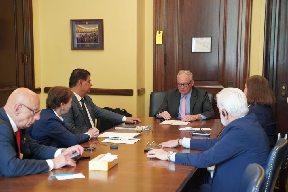 Senator Kaine engages in discussion at a table during his meeting with the lawmakers. 