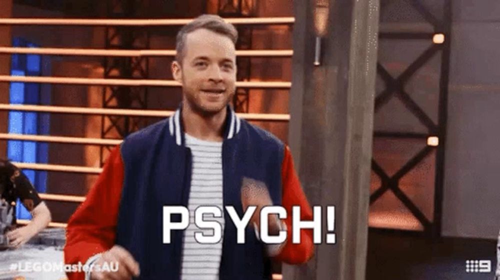 a man in a baseball jacket is standing in front of a podium and says psych !