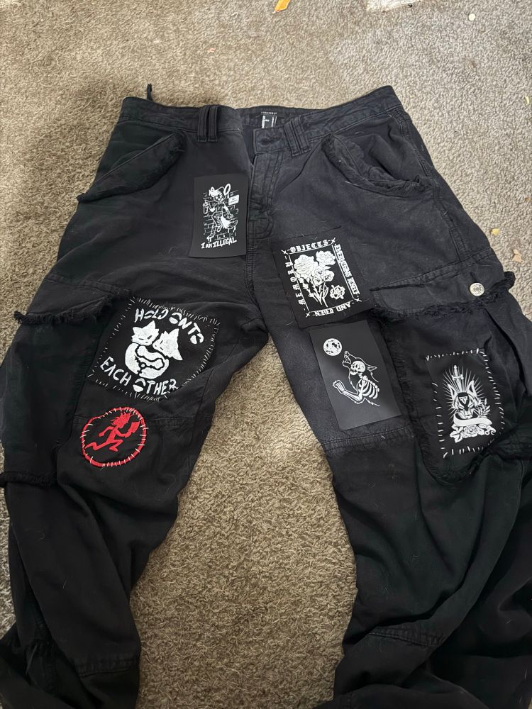 Black pants with patches sewn on with dental floss 