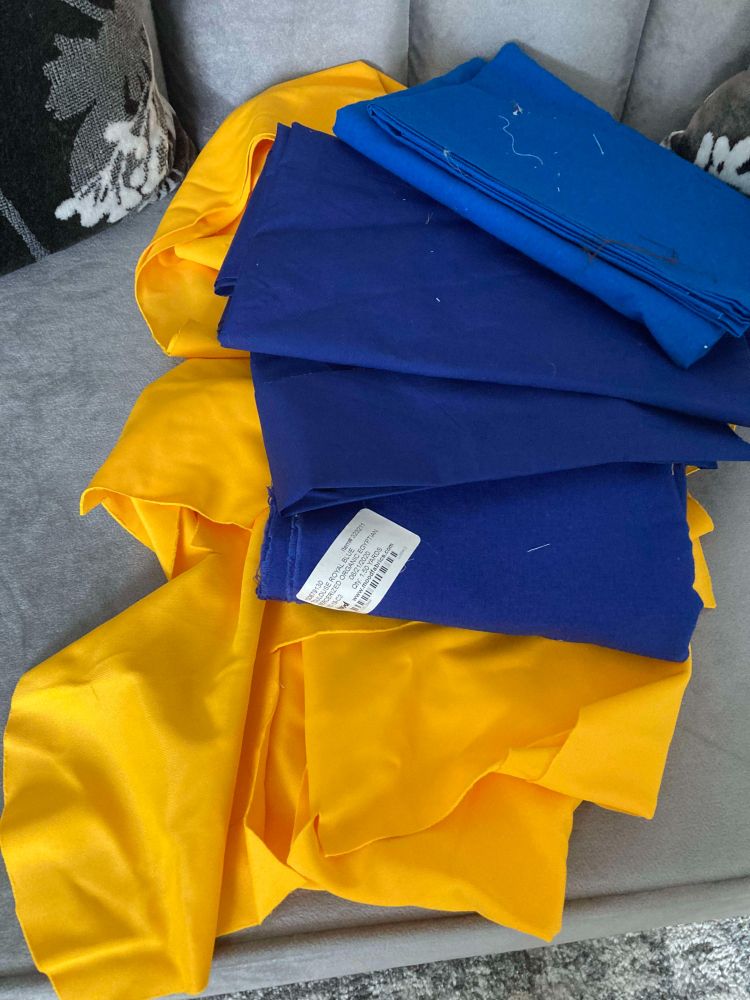 Folded piles of blue and yellow fabrics.