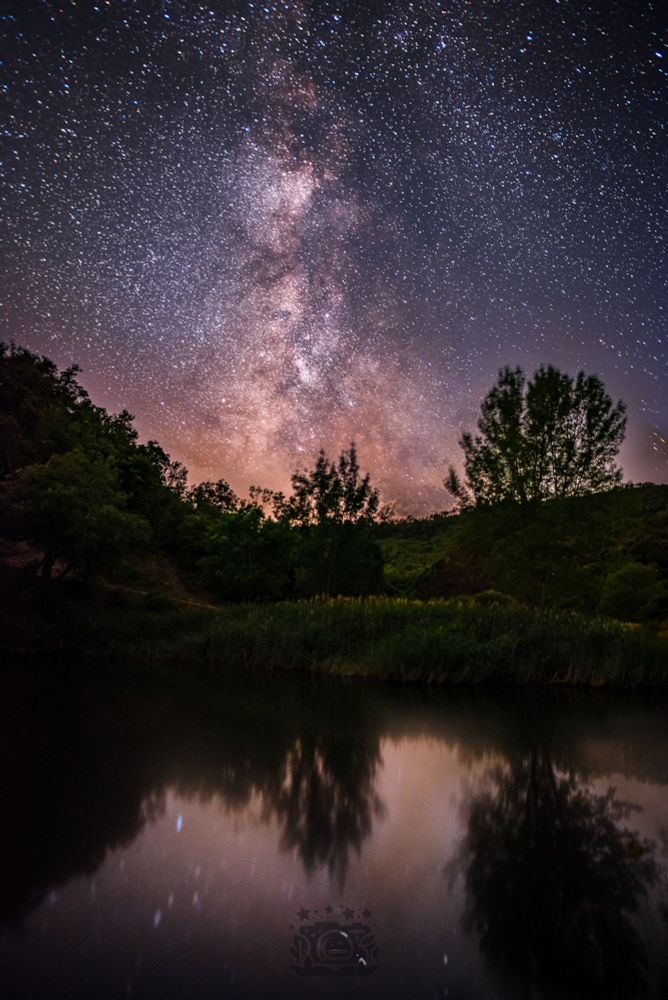 the Milky Way, rising in full splendor above a tranquil riverbank, where the frogs sing loud as they wants to Talk to the stars. And they, the stars, shimmer densely across the sky, revealing the galaxy’s core with extraordinary clarity and depth. Below, a peaceful mirror of water reflects the surrounding trees, the faint hues of the night sky, the stars.. creating a poetic dialogue between the heavens and the earth, just broken by the wind, that wanted to be part of this magic moment. The entire scene is bathed in serenity, as if time itself had paused to admire the cosmos, from the space to the waters.

Stack of 175 photos x 25s. Somewhere in the Pyrenees Orientals, France.