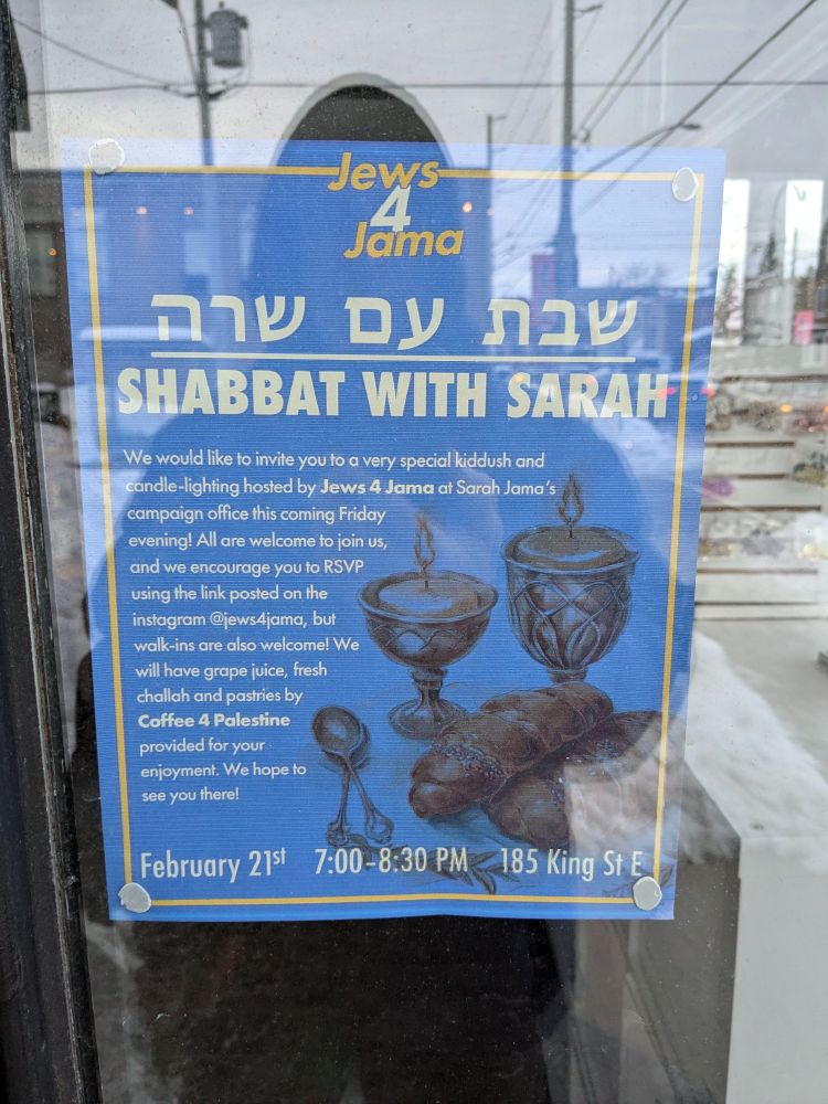 Image of a bill in a shop window promoting Shabbat with Sarah, a ceremony to mark the beginning of Shabbas being held at the campaign headquarters of Sarah Jama Friday February 21 at 7 pm. The event is sponsored by a group called Jews 4 Jama. 