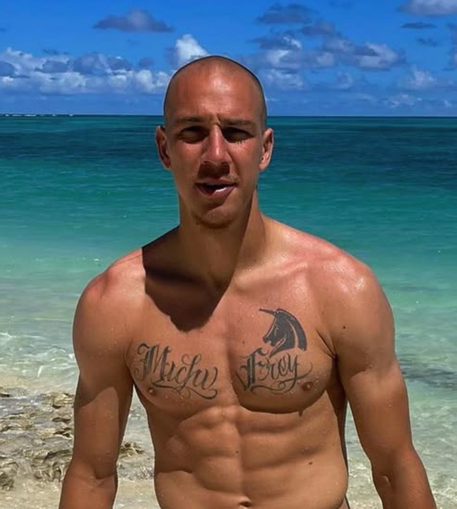 Buff 2022 Michi Frey on the beach. The hair has gone, but his chest tattoo now reads ‘Michi Frey’ just in case you didn’t recognise him anymore.