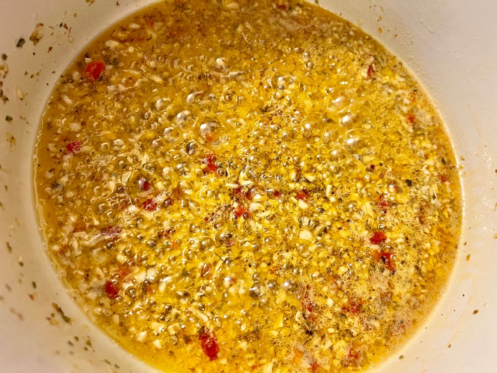 Garlic, oregano, and chilies cooking in olive oil and butter
