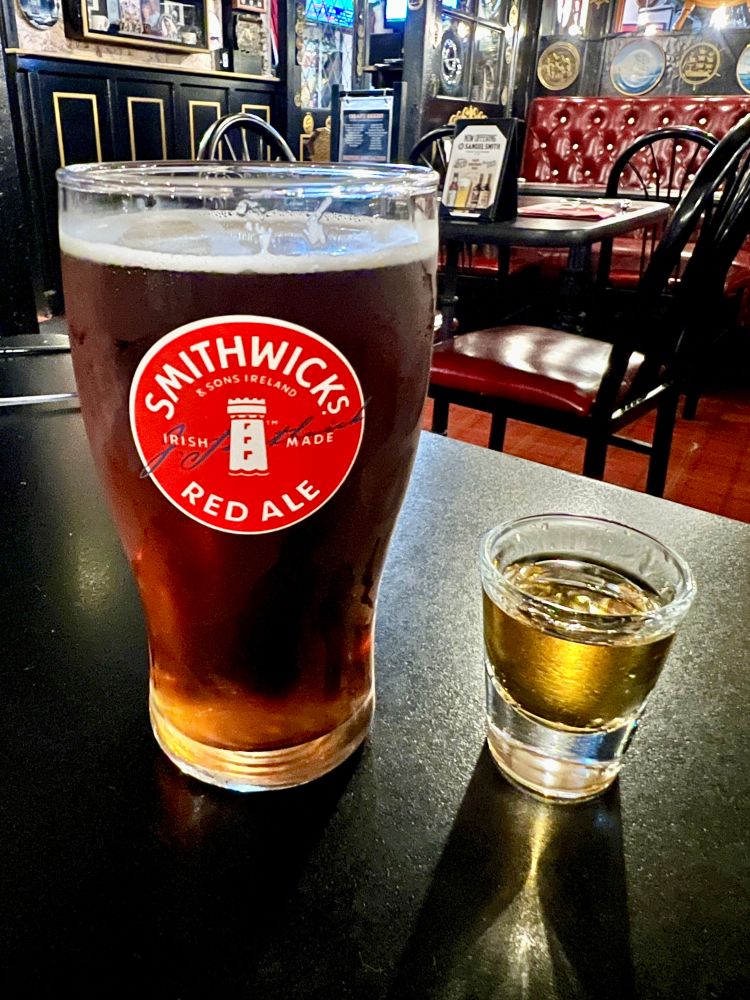 A pint of Smithwick’s red ale with the red logo on the glass, and a shot of Irish whiskey
