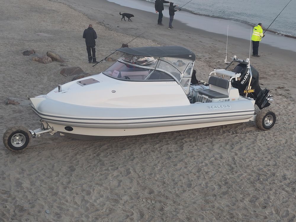 A speedboat on a beach...with a retractable wheel at the front and two at the rear. It can use these to manoeuvre on land and drive itself into the sea. When it is deep enough that it floats, the wheels rise clear of the water and the boat is once more a boat again.