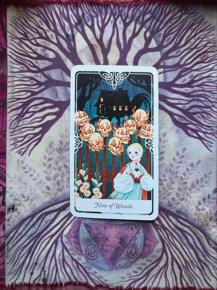 Tarot card of the Nine of Wands from Yoshi Yoshitani's Tarot of the Divine deck. The card depicts the Russian fairy tale, Vasilisa the Beautiful. 