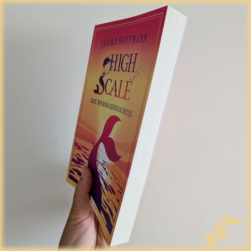 Das Buch "High Scale – Die Mermaidingschule" wird vor weißem Hintergrund schräg in die Kamera gehalten, sodass das Cover noch zu sehen ist, aber auch der Buchschnitt und dass das Buch etwa einen Daumenbreit dick ist. 