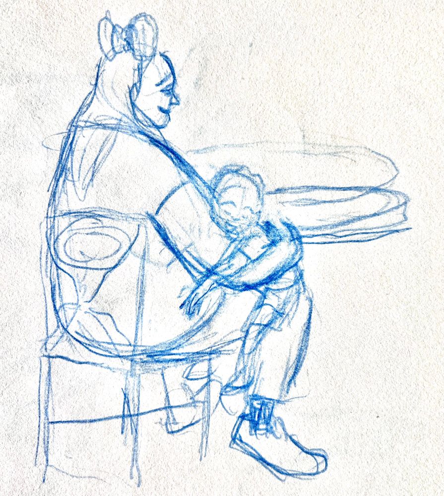 A woman is holding her child carefully. The child is asleep while the woman gives her sleepy child a warm smile. She’s wearing Mickey ears.
From Plaza restaurant on Main Street in Magic Kingdom.
Sketch by Luke Perkins (10/18/25)