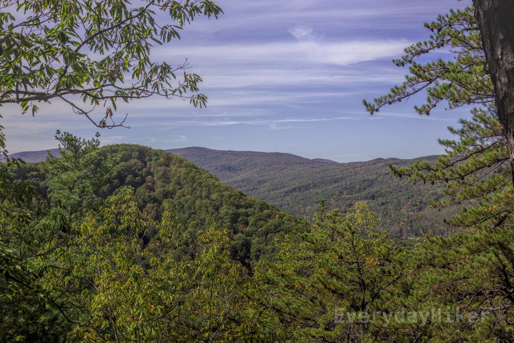The rolling mountains beginning to yellow under streaky clouds.