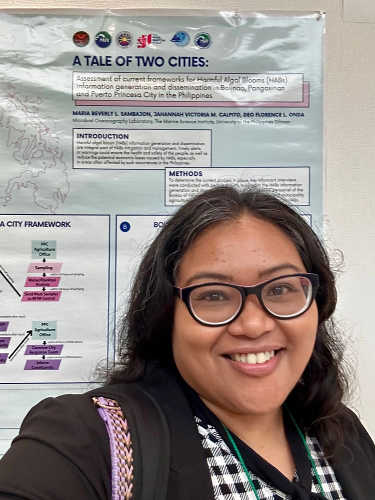 Close up of a woman standing in front of her poster at the International Conference on Harmful Algae 2023 in Hiroshima, Japan. The poster reads “A tale of two cities: Assessment of current frameworks for Harmful Algal Blooms (HABs) information generation and dissemination in Bolinao, Pangasinan and Puerto Princesa City in the Philippines”
