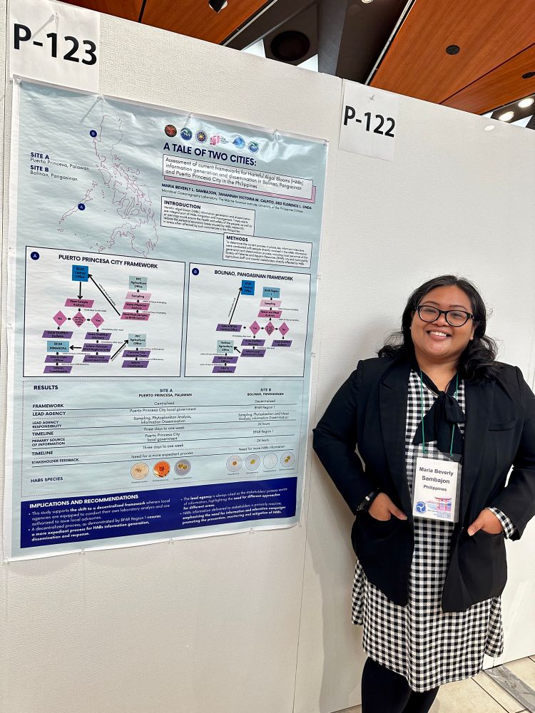 Woman standing next to her poster at the International Conference on Harmful Algae 2023 in Hiroshima, Japan.