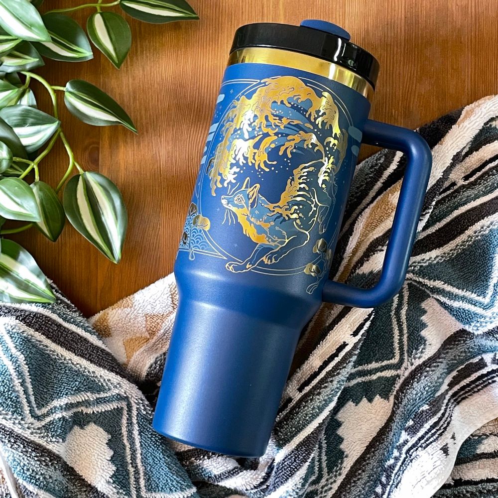 a blue gold tumbler with a laser engraved fox