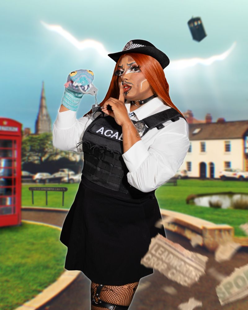 Diomede poses as Amy Pond, in police officer kissogram outfit and ginger wig, one finger up to his lips. His other hand operates a knitted sock puppet Prisoner Zero, which holds handcuffs in its jaws. Amy's uniform reads ACAB across the front of the protective vest. There is an edited in background of Leadworth village, featuring the green and mysteriously empty duck pond. In the sky is a huge space time crack, and the TARDIS is seen flying nearby.